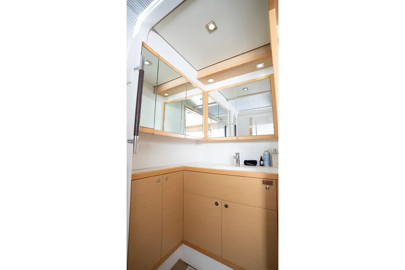 Bluewinds Yacht Photos Pics Modern bathroom interior of 2023 Lagoon 560 S2 yacht with mirrored cabinets.