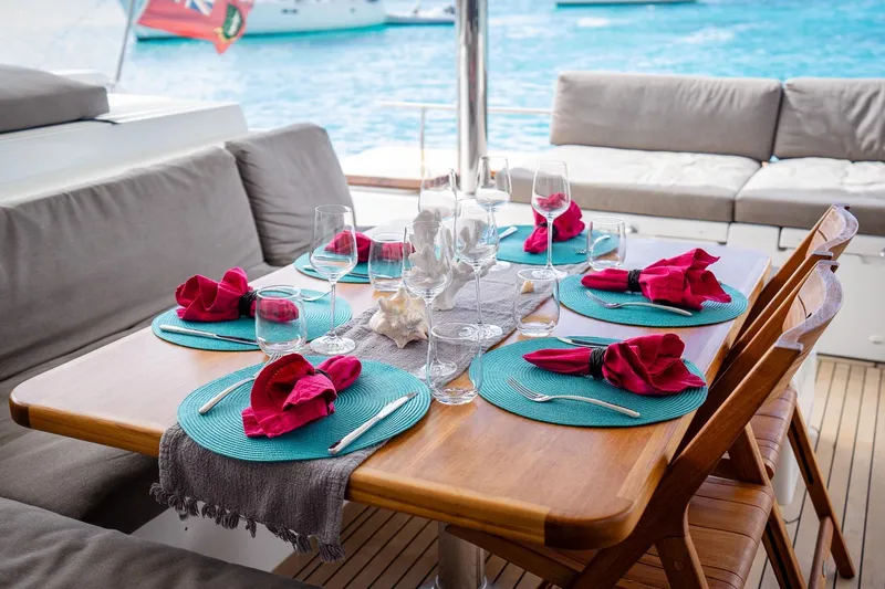 Bluewinds Yacht Photos Pics Elegant dining setup on Lagoon 560 S2 yacht, 2023, with ocean view and vibrant decor.