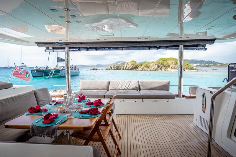 Bluewinds Yacht Photos Pics Luxurious Lagoon 560 S2 yacht interior with elegant dining setup, overlooking serene turquoise waters.