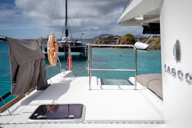 Bluewinds Yacht Photos Pics 2023 Lagoon 560 S2 yacht on turquoise waters, featuring deck view and life preserver.