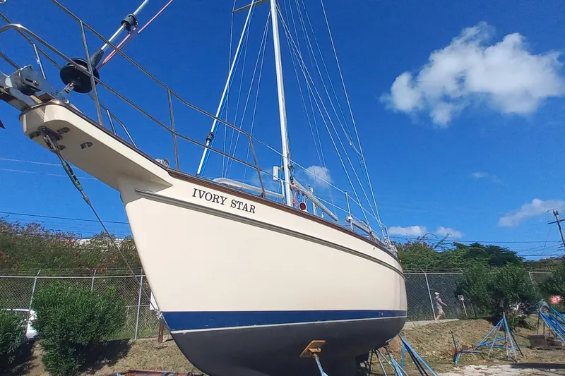 Ivory Star Yacht Photos Pics 1999 Island Packet 350 sailboat "Ivory Star" on land under clear blue sky.