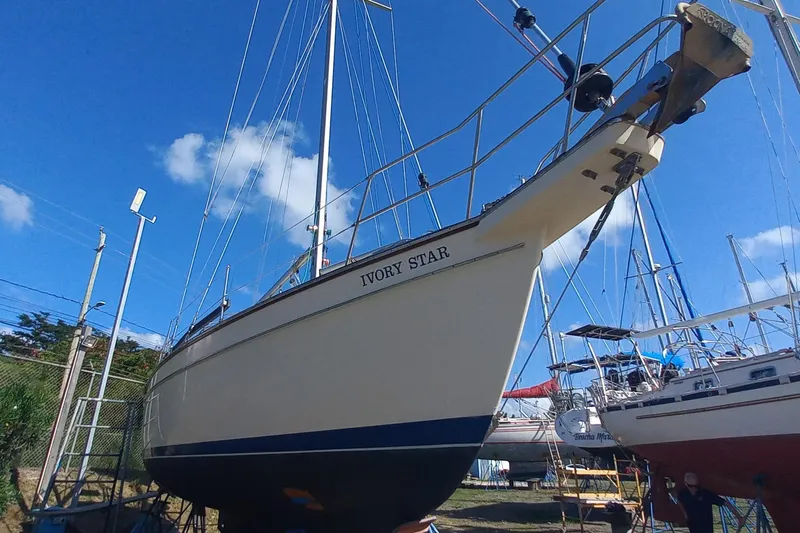 Ivory Star Yacht Photos Pics 1999 Island Packet 350 sailboat "Ivory Star" on land under clear blue sky.