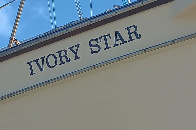 Ivory Star Yacht Photos Pics 1999 Island Packet 350 sailboat named "Ivory Star" with blue sky background.