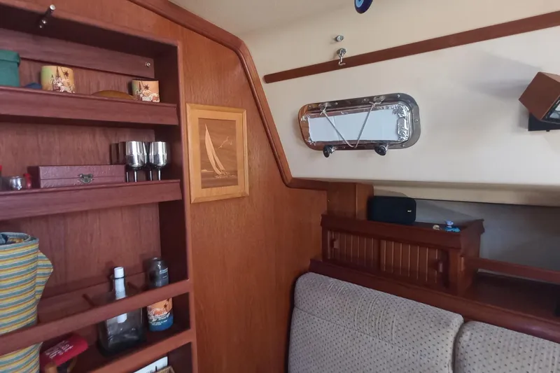 Ivory Star Yacht Photos Pics Interior of 1999 Island Packet 350 sailboat with wooden shelves and nautical decor.