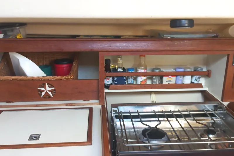Ivory Star Yacht Photos Pics 1999 Island Packet 350 yacht kitchen with stove, spice rack, and storage baskets.