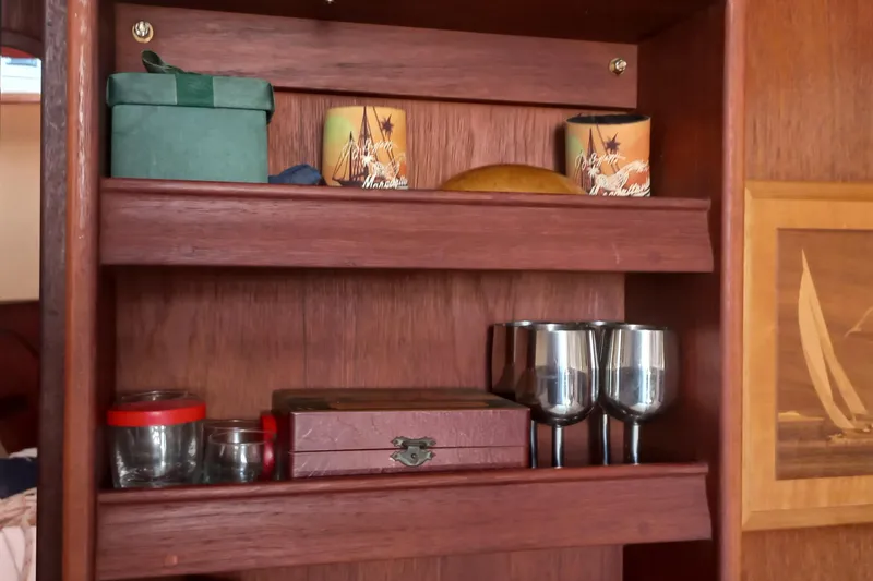 Ivory Star Yacht Photos Pics Wooden cabinet with decorative items and glasses on an Island Packet 350, 1999 model.