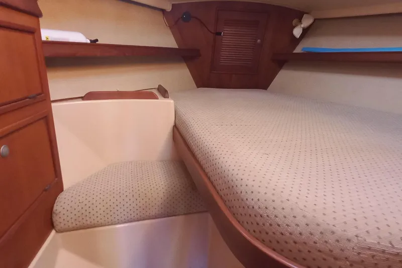 Ivory Star Yacht Photos Pics 1999 Island Packet 350 interior cabin with cozy bed and wooden storage.