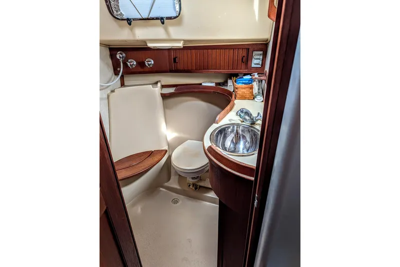 Ivory Star Yacht Photos Pics 1999 Island Packet 350 yacht bathroom with sink, toilet, and wooden accents.