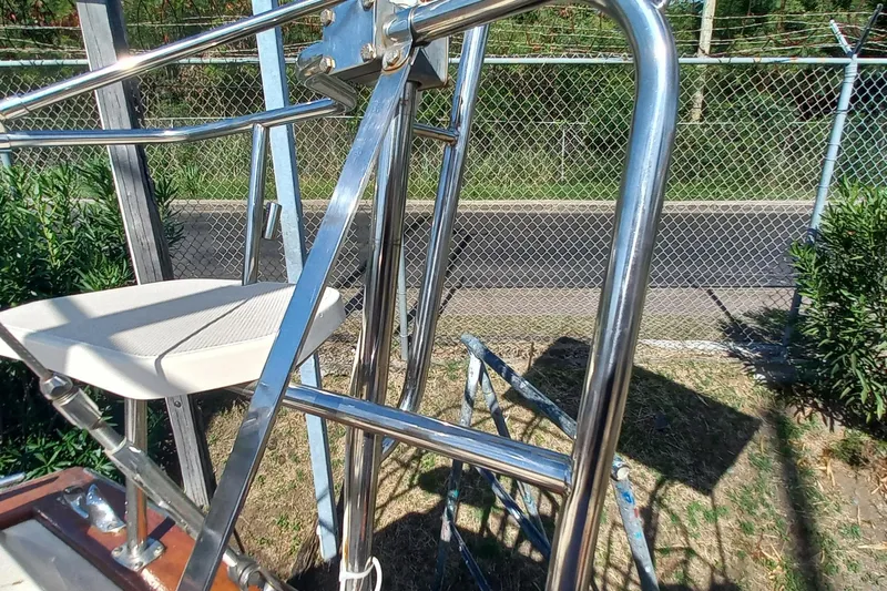Ivory Star Yacht Photos Pics Stainless steel structure on a 1999 Island Packet 350 sailboat, near a chain-link fence.