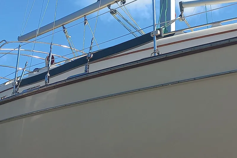 Ivory Star Yacht Photos Pics 1999 Island Packet 350 sailboat, close-up of deck and railing under clear blue sky.