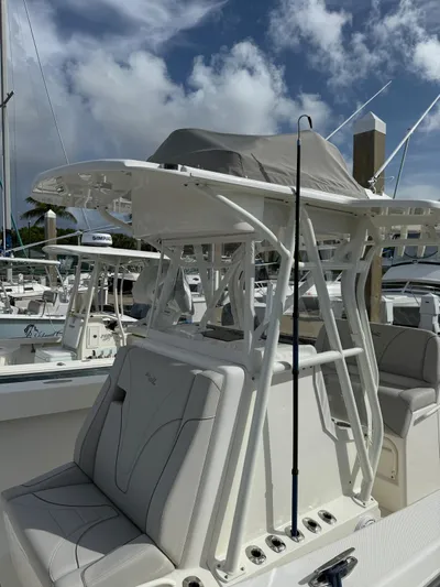 Seavee Yacht Photos Pics 2025 SeaVee 320Z boat with T-top and cushioned seating at a marina.