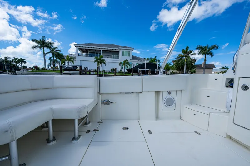 Absent Minded Yacht Photos Pics 2014 SeaVee 430 boat interior with white seating, docked near a waterfront home.