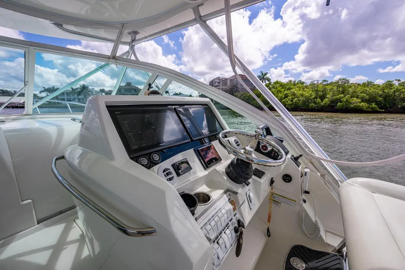 Absent Minded Yacht Photos Pics Helm of 2014 SeaVee 430 boat with modern controls and scenic waterway view.