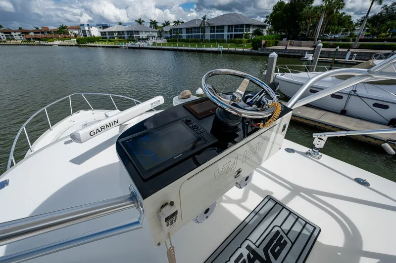 Absent Minded Yacht Photos Pics 2014 SeaVee 430 boat helm with Garmin navigation system, docked near waterfront homes.
