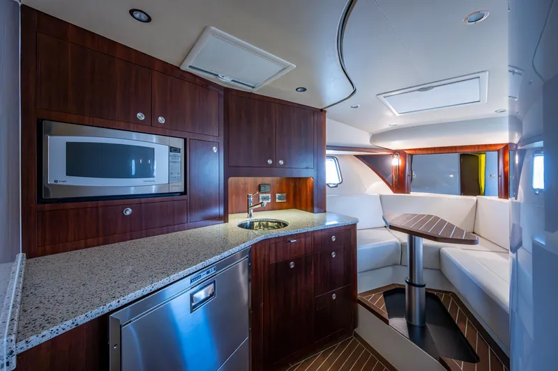 Absent Minded Yacht Photos Pics Luxurious 2014 SeaVee 430 yacht interior with modern kitchen and cozy seating area.