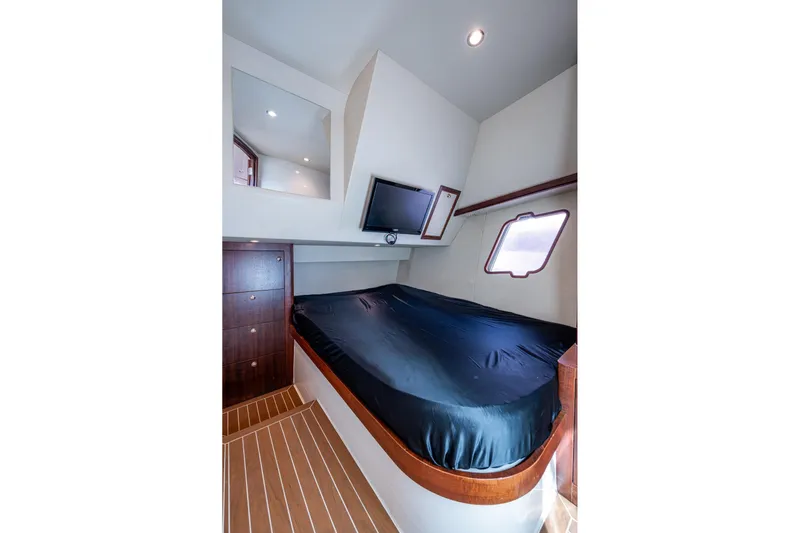 Absent Minded Yacht Photos Pics 2014 SeaVee 430 cabin interior with bed, TV, and wooden flooring.