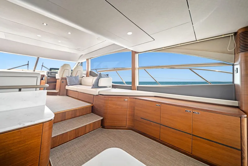 Mine Escape Yacht Photos Pics Luxurious interior of 2020 Princess F55 Flybridge yacht with panoramic windows and elegant wood finishes.
