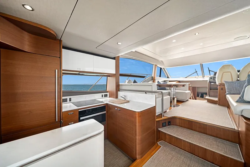 Mine Escape Yacht Photos Pics Luxurious interior of 2020 Princess F55 Flybridge yacht with modern kitchen and seating area.