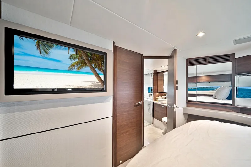 Mine Escape Yacht Photos Pics Luxurious bedroom interior of 2020 Princess F55 Flybridge yacht with TV and ensuite bathroom.