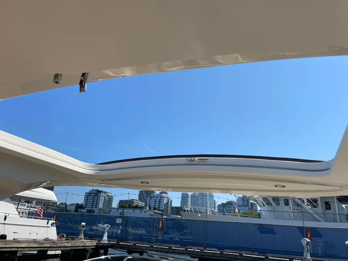  Yacht Photos Pics 2021 Sea Ray SLX 310 boat with open sunroof, docked under clear blue sky.