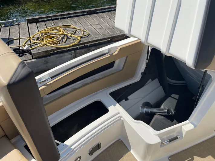  Yacht Photos Pics 2021 Sea Ray SLX 310 boat interior with open storage compartment by the dock.