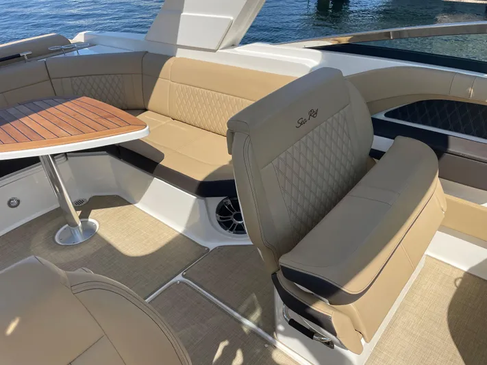  Yacht Photos Pics 2021 Sea Ray SLX 310 boat interior with tan seating and wooden table.