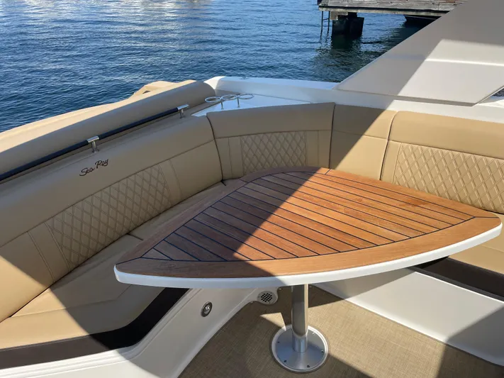 Yacht Photos Pics 2021 Sea Ray SLX 310 boat interior with tan seating and wooden table.