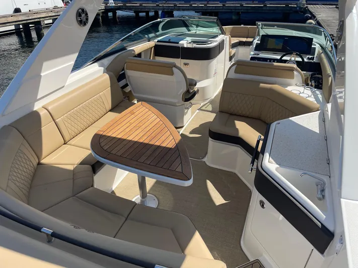  Yacht Photos Pics 2021 Sea Ray SLX 310 boat interior with tan seating and wooden table.