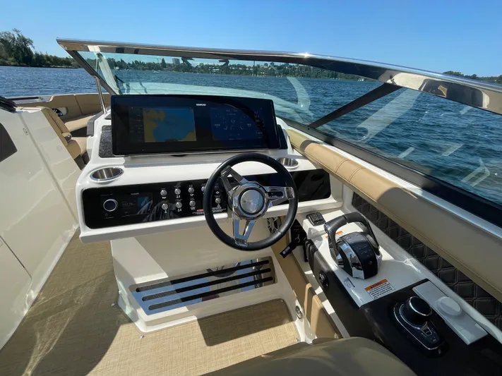  Yacht Photos Pics 2021 Sea Ray SLX 310 boat cockpit with steering wheel and control panel.
