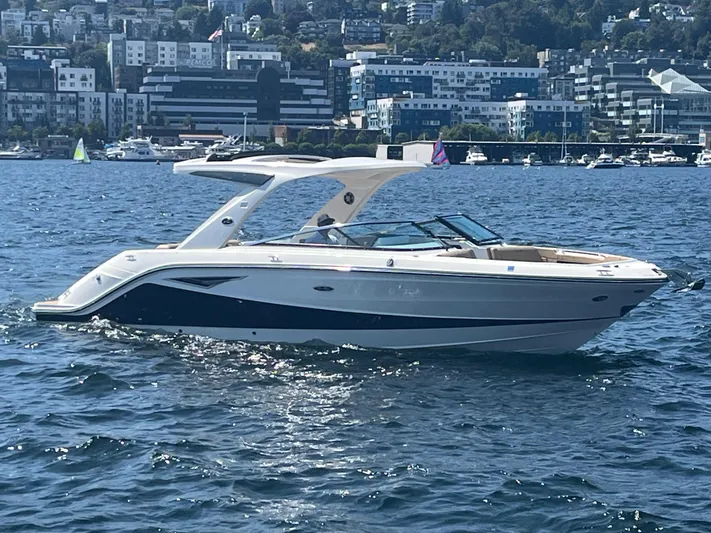  Yacht Photos Pics 2021 Sea Ray SLX 310 boat cruising on a sunny day with cityscape background.