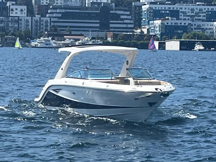  Yacht Photos Pics 2021 Sea Ray SLX 310 boat cruising on a sunny day in urban waters.