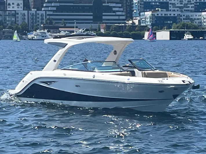  Yacht Photos Pics 2021 Sea Ray SLX 310 boat cruising on a sunny day in a city harbor.