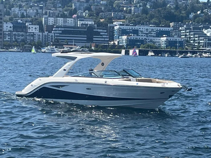  Yacht Photos Pics 2021 Sea Ray SLX 310 boat cruising on a sunny day near urban waterfront.