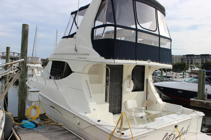  Yacht Photos Pics 2007 Silverton 36 Convertible yacht docked at marina, featuring spacious deck and upper helm.