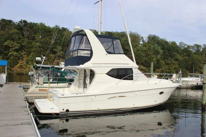  Yacht Photos Pics 2007 Silverton 36 Convertible yacht docked at a marina, surrounded by lush greenery.