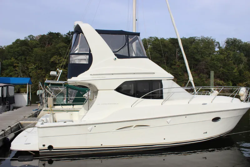  Yacht Photos Pics 2007 Silverton 36 Convertible yacht docked by a forested shoreline.