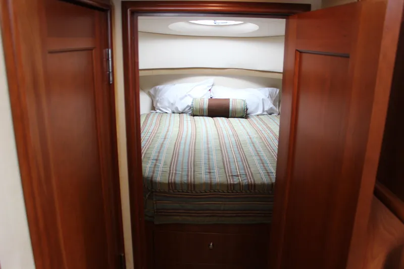  Yacht Photos Pics Cozy bedroom in 2007 Silverton 36 Convertible yacht with striped bedding and wooden doors.