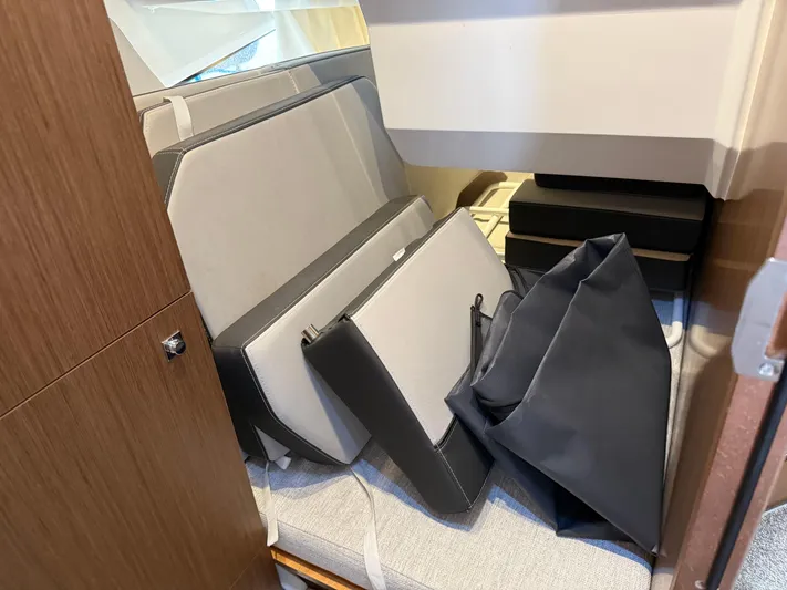  Yacht Photos Pics Interior storage area of 2022 Jeanneau NC 1095 Coupe with cushions and bags.