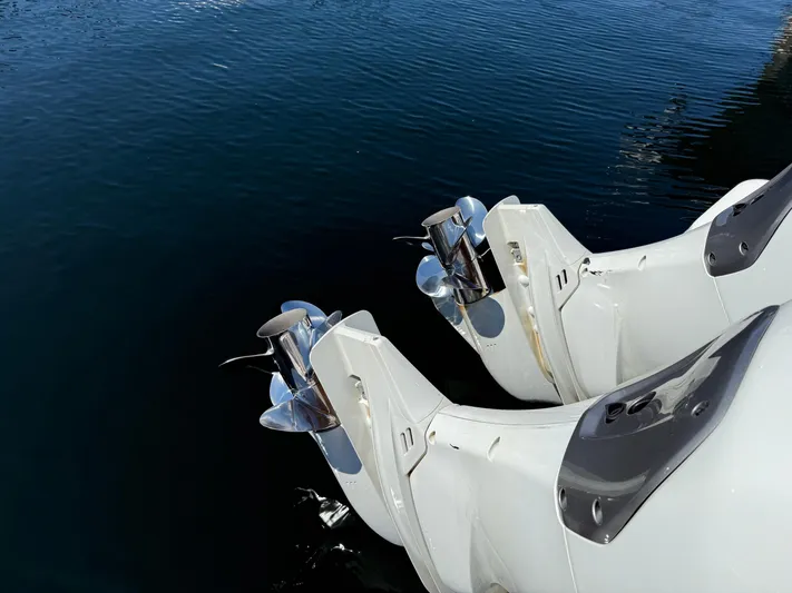  Yacht Photos Pics Twin outboard motors on a 2022 Jeanneau NC 1095 Coupe, reflecting on calm water.