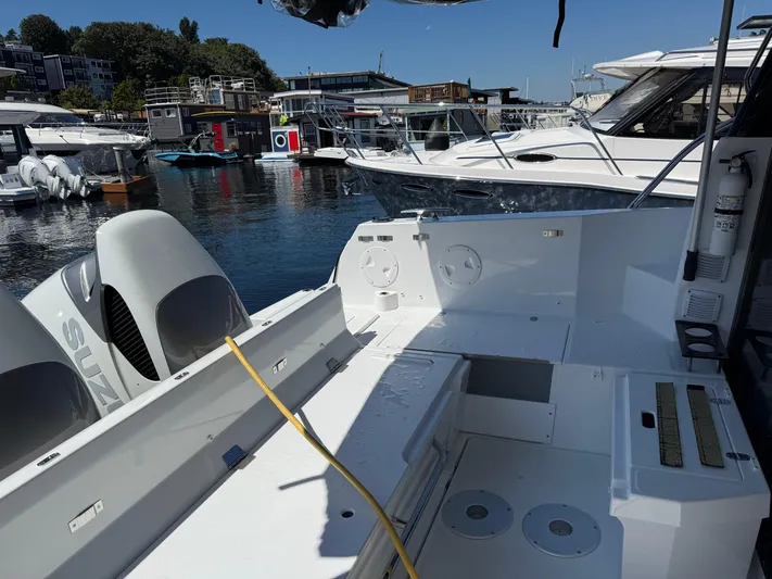  Yacht Photos Pics 2022 Jeanneau NC 1095 Coupe boat docked, featuring spacious deck and dual Suzuki engines.