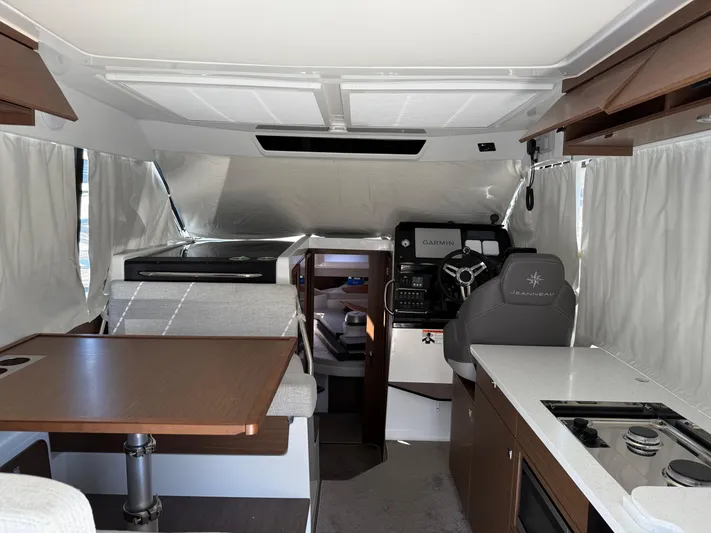  Yacht Photos Pics Interior of 2022 Jeanneau NC 1095 Coupe, featuring helm, dining area, and kitchen.