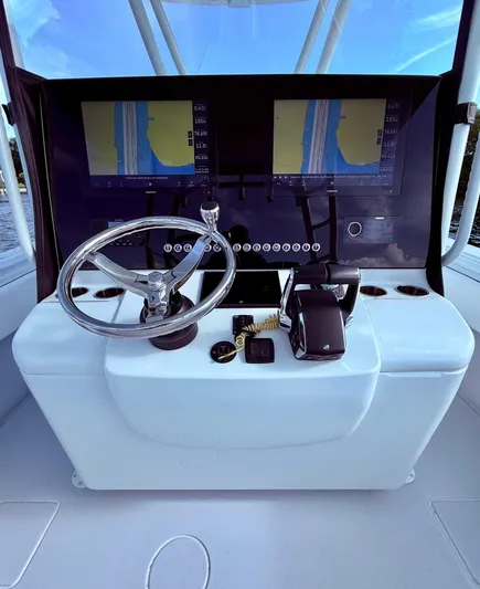  Yacht Photos Pics 2024 Contender 39 ST boat dashboard with dual navigation screens and steering wheel.