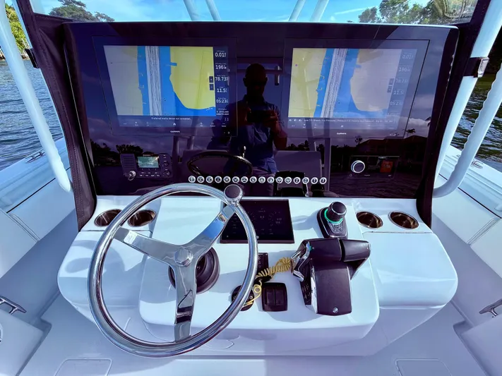  Yacht Photos Pics 2024 Contender 39 ST boat dashboard with dual navigation screens and steering wheel.