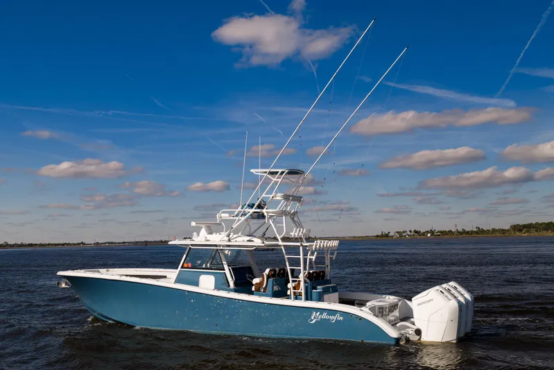Fishistics Yacht Photos Pics 2024 Yellowfin 42 Offshore boat cruising on open water under a clear blue sky.