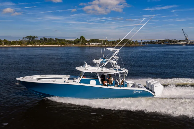 Fishistics Yacht Photos Pics 2024 Yellowfin 42 Offshore boat cruising on a sunny day, showcasing sleek design and powerful engines.