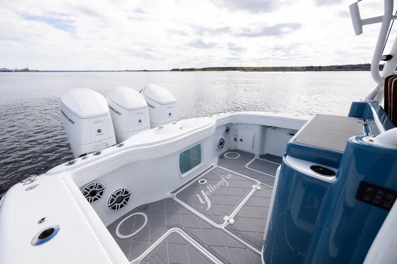 Fishistics Yacht Photos Pics 2024 Yellowfin 42 Offshore boat with triple Mercury engines on calm water.