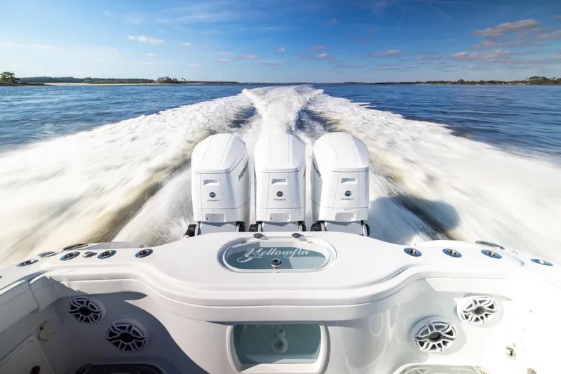 Fishistics Yacht Photos Pics 2024 Yellowfin 42 Offshore boat speeding on open water, showcasing powerful engines.