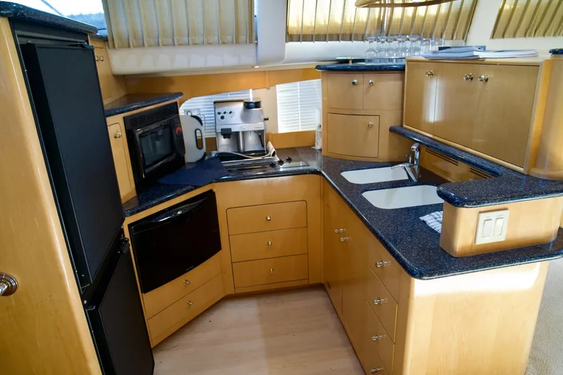  Yacht Photos Pics Luxurious kitchen in a 2000 Carver 506 Motor Yacht with modern appliances and wood cabinetry.