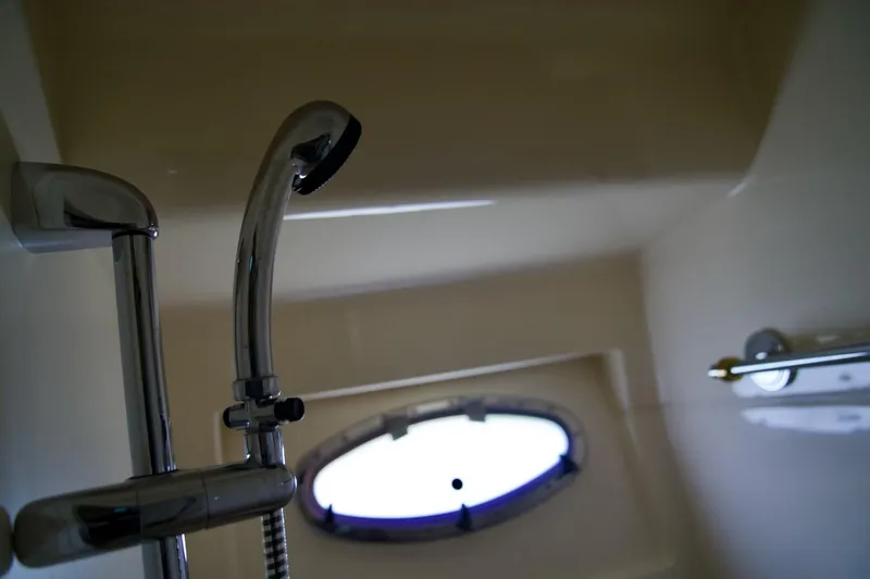  Yacht Photos Pics Shower area inside a 2000 Carver 506 Motor Yacht, featuring chrome fixtures and a porthole window.