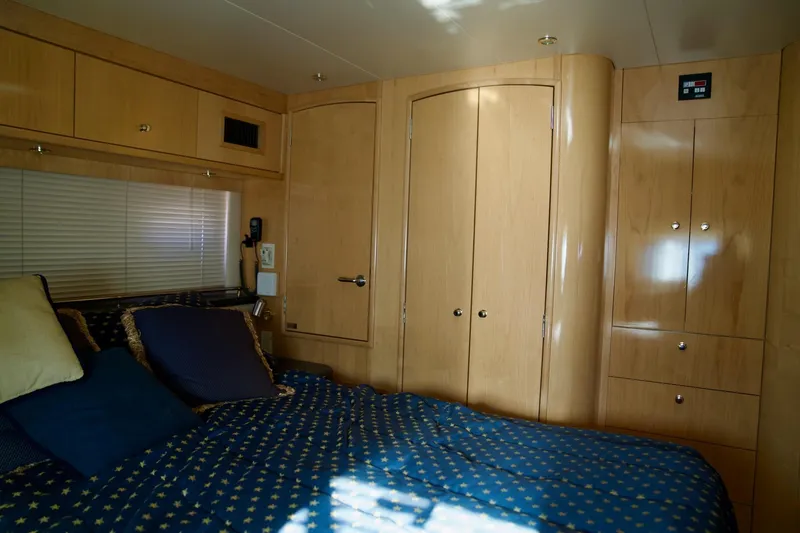  Yacht Photos Pics Luxurious bedroom interior of 2000 Carver 506 Motor Yacht with wood cabinetry and cozy bedding.